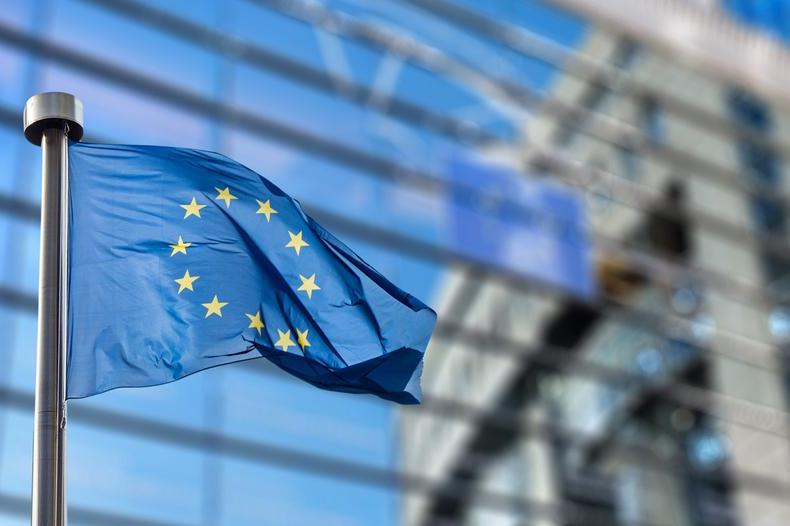 image of an EU flag against a glass building