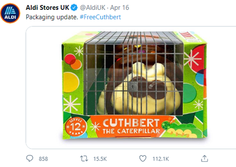 Tweet from @AldiUK with a picture of a caterpillar cake in a cage, reading "Packaging update"