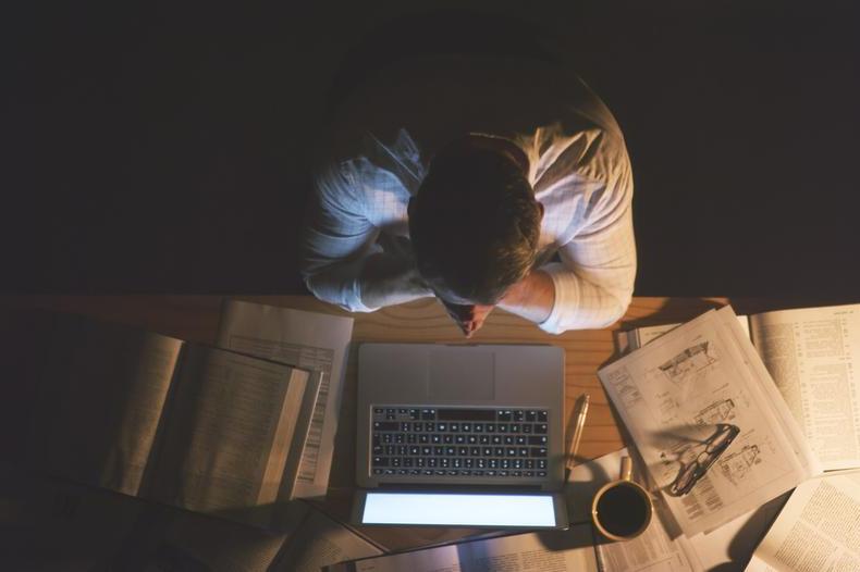 man at desk with coffee and papers