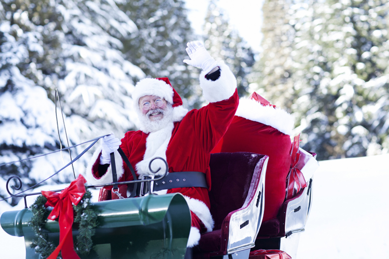 santa sits on his sleigh and waves