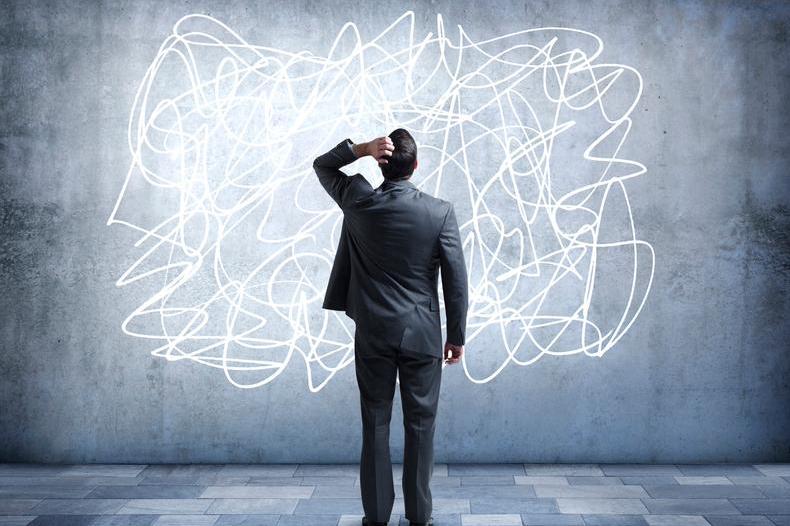 a man in a suit stares at a wall covered in white scribble lines